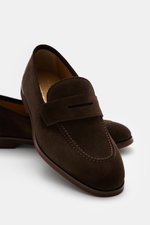Henderson Penny Loafer 'Modica' dark brown shown from a close-up front-side angle, made of supple suede leather, narrow tapered silhouette, typical penny strap, decorative stitch on front cap, Goodyear-welted, leather lining, natural rubber outsole, with 