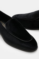 Close-up image of the Henderson Loafer 'Velluto' black from a slightly elevated front side view, showcasing soft velvet velour, slim tapering silhouette, and decorative seam on the toe cap, featuring leather lining, sole made of leather and rubber, heel w