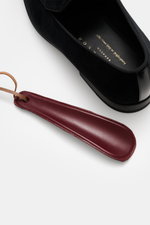 Close-up top-side view of the Henderson Loafer 'Velluto' black in soft velvet velour with leather lining and a burgundy leather shoehorn.

Description: <p>The gala can begin: The Loafer 'Velluto' by HENDERSON impresses with soft velvet velour and perfectl