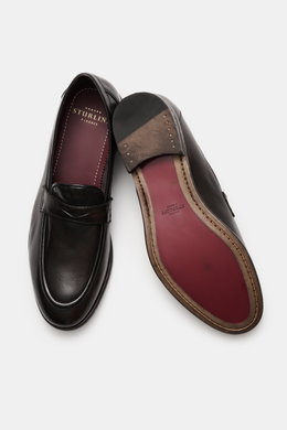 Top-down view of Sturlini Penny loafers 'Bufalo' dark brown, showing smooth leather, Blake-stitched design, tapered silhouette, signature penny strap, distinctive topstitching on toe cap, and leather-rubber outsole. 

<p>The 'Bufalo' penny loafers by STUR