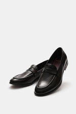 Dark brown Sturlini Penny loafers 'Bufalo' shown from a front-side angle, featuring fine smooth leather and tapered silhouette.

Description: 
<p>The 'Bufalo' penny loafers by STURLINI bring preppy style into modern balance with a touch of nonchalance and