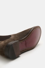Close-up bottom and side view of the Sturlini Chelsea Boot 'Crosta Piuma' dark brown in noble suede leather with Goodyear welted sole, elastic inserts, leather lining, grosgrain pull tab, and rubber-reinforced heel, showcasing its slightly narrow tapering