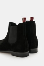 Close-up rear view of Sturlini Chelsea Boot 'Crosta Piuma' black in noble suede leather with elastic inserts and grosgrain pull tab.

Description: A classic from the Italian manufacturer STURLINI is definitely the welted Chelsea Boot 'Crosta' – made from 