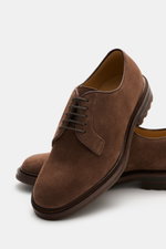 Brunello Cucinelli Derby braun aus softem Veloursleder, schmal zulaufend, offene Fünf-Loch-Schnürung, profilierte Gummisohle, Nahaufnahme schräg oben.