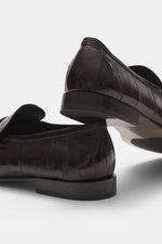 The Row Loafer dunkelbraun aus softem, exotischem Aal-Leder, schmal zulaufend mit Ziernaht, ledernem Futter und Kautschukeinsätzen, seitliche Perspektive.