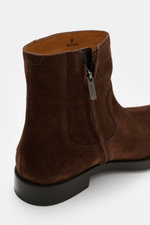 Close-up side view of Tod's Ankle boot dark brown made of noble suede leather, featuring a slightly slim tapering silhouette, side zipper, high shaft, leather lining, and lightly profiled rubber sole.