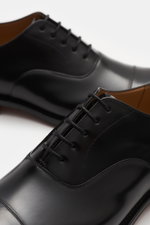 Close-up front-side perspective of Church's Oxford shoes 'Consul' black, polished calf leather, Goodyear welted, narrow toe cap, closed five-eyelet lacing, leather lining, leather outsole, rubber-reinforced heel.