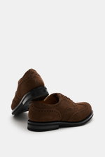 Side and rear view of Church's Fullbrogue 'Amersham' brown modern Oxford shoes made of fine suede leather with fullbrogue, narrow tapered shape, curved toe cap, closed five-eyelet lacing, leather lining, rubber outsole, and rubber heel.