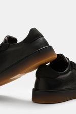 Fabiano Ricci Sneaker 'Double TDM' schwarz aus genarbtem Leder in Nahaufnahme von der Seite, mit runder Vorderkappe, elastischer Sieben-Loch-Schnürung, gepolsterter Innensohle und flexibler Gummisohle.