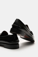 Sebago Penny loafers 'Classic Dan' black shown from a low rear and side angle, highlighting finely grained leather, through-sewn Blake-stitched finish, slightly tapered cut, signature penny strap, toe cap with decorative stitching and pleats, leather lini