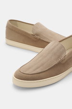 Brunello Cucinelli Loafer beige shown from a side and slightly top angle, soft suede leather, tapered shape, embossing on upper, decorative seam, light unlined, rubber outsole.