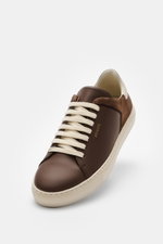Axel Arigato Sneaker 'Clean 90 Split' braun/offwhite, frontal aus schräger Perspektive, Glatt- und Veloursledermix, runde Vorderkappe, sieben-Loch-Schnürung, goldfarbene Label-Prägung, gepolsterter Schaftrand, Leder-Innenfutter, flexible Gummisohle.