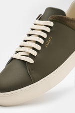 Close-up front-side view of the Axel Arigato Sneaker 'Clean 90 split' dark olive/offwhite showcasing a minimalist mix of smooth and suede leather, round toe cap, seven-hole cream lacing, gold label embossing, padded collar, leather lining, and flexible of
