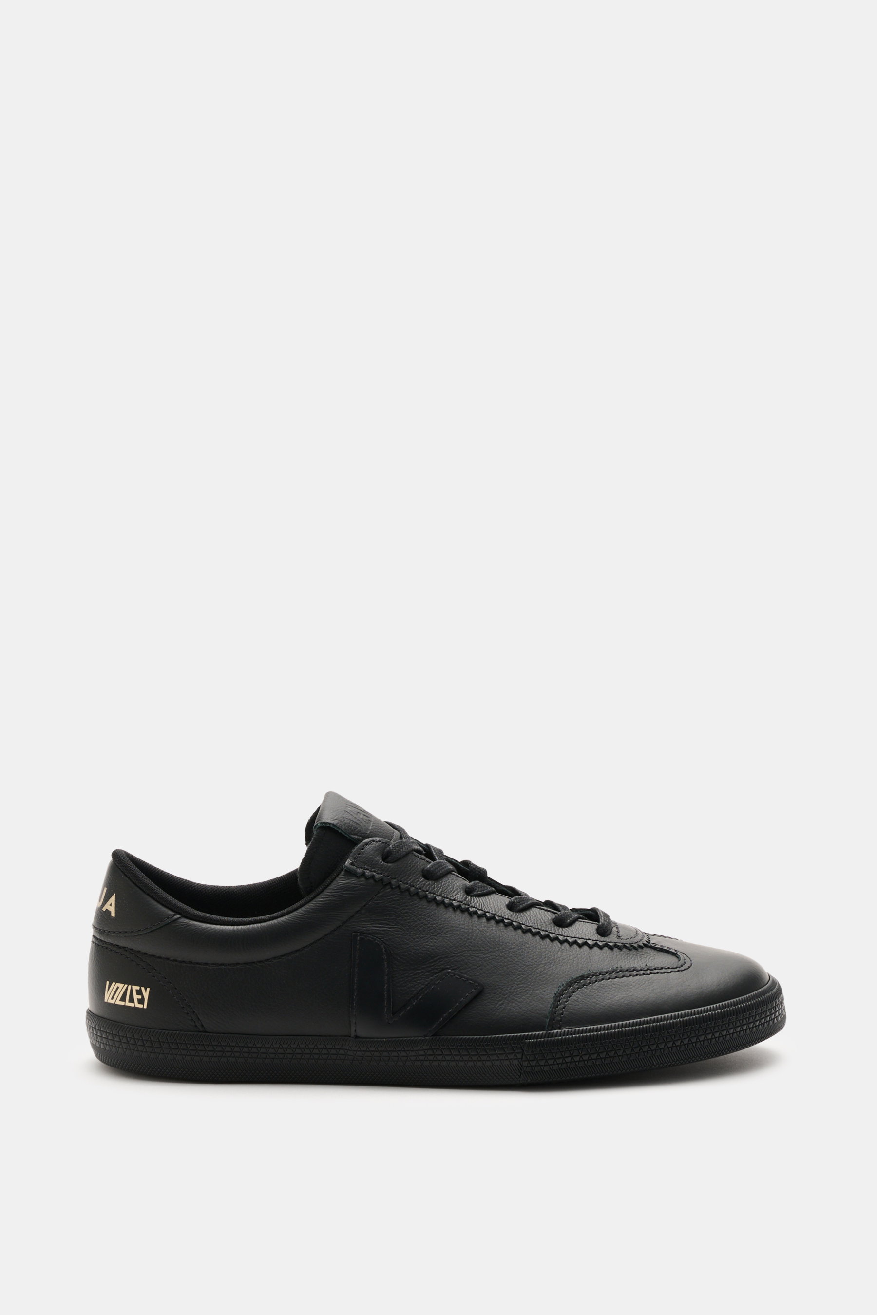 Side view of Veja Sneaker 'Volley O.T. Leather' schwarz in black, featuring smooth O.T. leather, overlays, round toe, six-eyelet lacing, V-overlay, padded collar with logo, logo patch tongue, textile lining, and flexible rubber sole with recycled content.