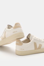 Veja Sneaker 'Campo' weiß/beige shown from a rear side angle, crafted from chrome-free tanned grain leather with beige velour overlays, round toe, seven-hole lacing, V-shaped overlay, padded collar with logo, gold VEJA embossing, textile lining, and flexi