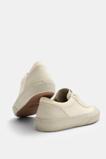 Stone Island Sneaker cream/sand shown from a low rear side angle, made of canvas and suede leather, with round toe cap, surrounding rubber coating, five-hole lacing, logo patch on the tongue, textile lining, and durable rubber sole.