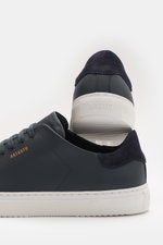 Close-up rear and side view of Axel Arigato Sneaker 'Clean 90' navy in smooth leather with tonal suede detail, seven-hole lacing, rounded toe, gold label embossing, padded collar, leather lining, and flexible rubber sole.

<p>Bei diesem zurückhaltenden Sn
