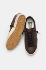 Golden Goose Sneaker 'Super-Star Classic' dark brown shown from top and sole view; fine nappa leather, vintage finish, star detail, seven-eyelet lacing, perforations, padded collar, and flexible rubber sole with used look.