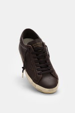 Golden Goose Sneaker 'Super-Star Classic' dark brown shown from a front angle, featuring fine nappa leather, vintage finish, seven-eyelet lacing, applied star, logo embossing on heel, padded collar, perforated sides, leather and terry cloth lining, and a 