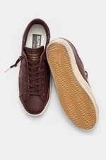 Golden Goose Sneaker 'Super-Star Classic' bordeaux aus feinem Nappaleder, Vintage-Finish, mit Stern, Used-Optik, von oben fotografiert.