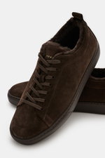 Henderson Sneaker 'Colby' dark brown shown from a close-up front-side angle, featuring soft suede leather, round toe cap, seven-hole lacing, logo embossing on the tongue, lambskin inner lining, practical pull tab, and light rubber outsole, ready for cold 