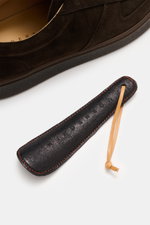 Close-up top-down view of Henderson Sneaker 'Levante' dark brown made of soft suede leather with round toe cap, five-eyelet lacing, logo embossing on tongue, perforated leather lining, and rubber outsole. 

<p>The sneaker 'Levante' by HENDERSON made of so