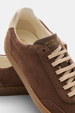 Brunello Cucinelli Sneaker braun aus geschmeidigem Veloursleder, schmal zulaufend, mit Flügelkappe, Sieben-Loch-Schnürung, Glattlederlasche und gepolstertem Schaftrand, seitliche Nahaufnahme.
