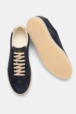 Brunello Cucinelli Sneaker navy aus geschmeidigem Veloursleder, schmal zulaufend, mit Flügelkappe, Sieben-Loch-Schnürung, Glattlederlasche und Naturgummisohle, von oben und seitlich fotografiert.