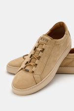 Tod's Slip-on Sneaker beige aus softem Veloursleder mit elastischer Schnürung und genoppter Sohle, Nahaufnahme schräg von vorne.