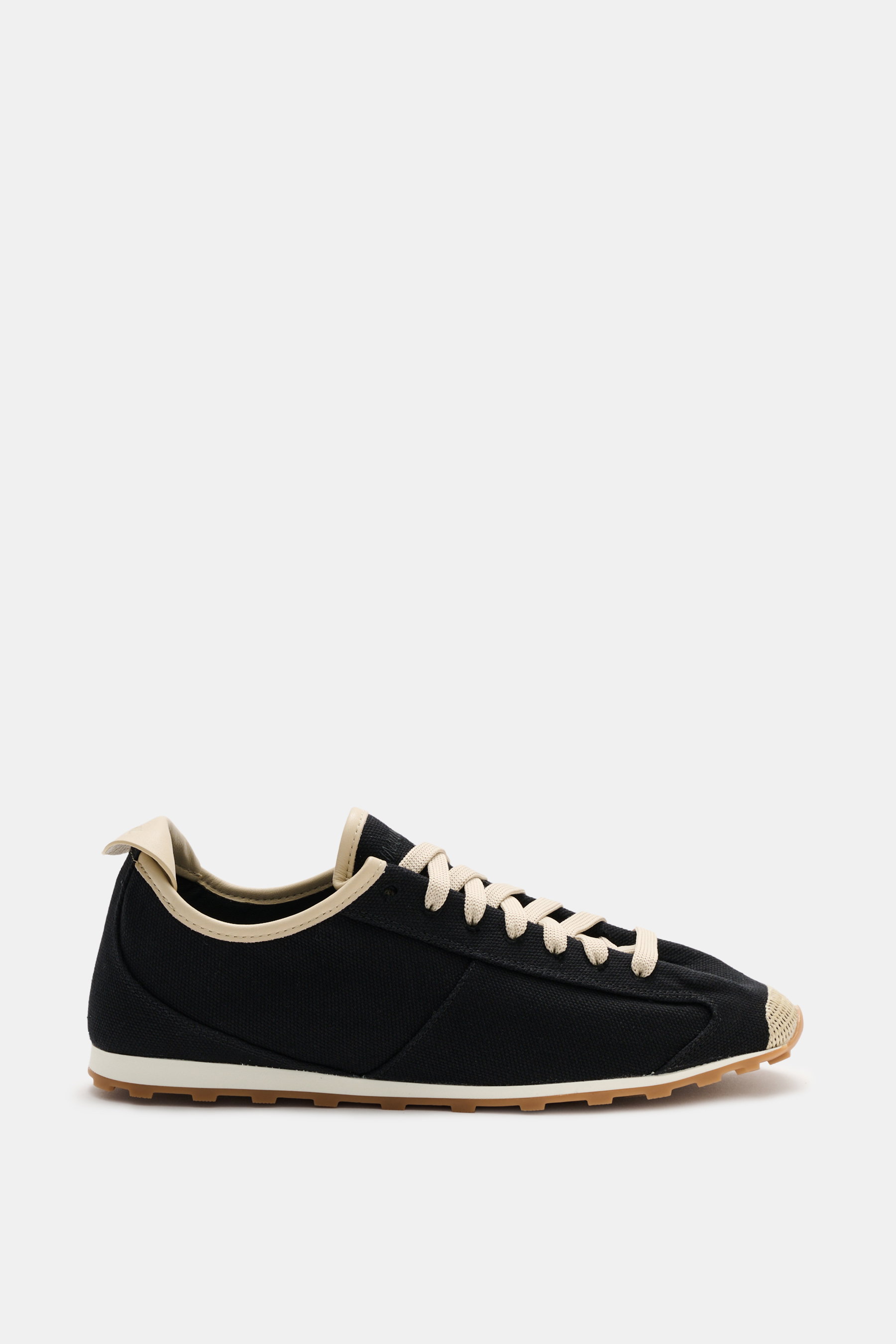 Side view of Jacquemus Sneaker 'Les Tennis' black/beige featuring durable canvas, seven-hole lacing, logo-embossed tongue, canvas overlays, leather lining, and ultraflexible rubber sole.
