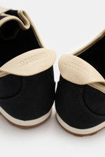 Close-up rear view of Jacquemus Sneaker 'Les Tennis' black/beige showing durable canvas, seven-hole lacing, shoe tongue with logo embossing, canvas overlays, leather lining, and ultraflexible rubber sole.
