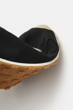 Close-up front angle of Jacquemus Sneaker 'Les Tennis' black/beige showing durable canvas, seven-hole lacing, shoe tongue with logo embossing, canvas overlays, leather lining, and ultraflexible rubber sole.