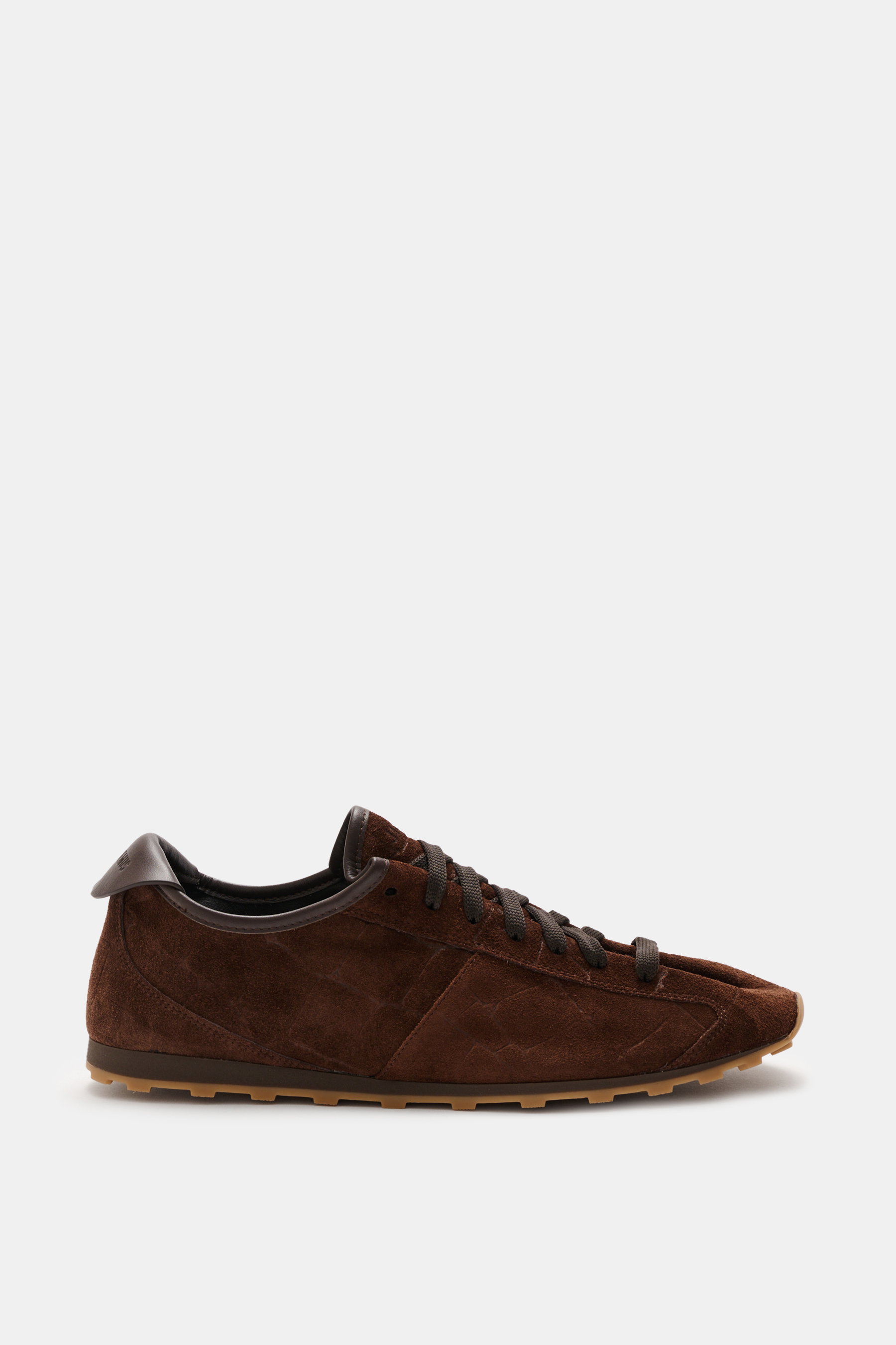 Side view of Jacquemus Sneaker 'Les Tennis' dark brown featuring supple suede leather, seven-eyelet lacing, tongue with logo embossing, overlays made of suede leather, leather lining, and an ultraflexible rubber sole.