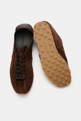 Jacquemus Sneaker 'Les Tennis' dark brown shown from top and sole views, featuring supple suede leather, seven-eyelet lacing, tongue with logo embossing, suede leather overlays, leather lining, and ultraflexible rubber sole.