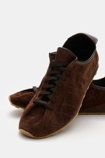 Jacquemus Sneaker 'Les Tennis' dark brown shown from a high front angle, featuring supple suede leather, seven-eyelet lacing, tongue with logo embossing, overlays made of suede leather, leather lining, and ultraflexible rubber sole.