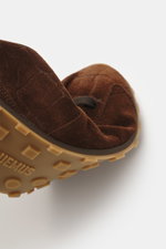 Close-up view from below of the Jacquemus Sneaker 'Les Tennis' dark brown, featuring supple suede leather, seven-eyelet lacing, tongue with logo embossing, overlays made of suede leather, leather lining, and an ultraflexible rubber sole.