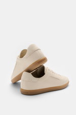 Zegna Sneaker sand shown from a rear-side angle, featuring grained leather, round toe cap, seven-eyelet lacing, shoe tongue with ZEGNA embossing, leather lining, and flexible rubber sole.