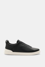 Zegna Slip-on Sneaker 'Triple Stitch' navy shown from side view, made of grained leather with round toe cap, crisscrossed elastic bands, high padded collar, pull tab, tongue with ZEGNA embossing, leather lining, and flexible rubber sole. Inspired by iconi