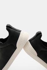 Side view of Zegna Slip-on Sneaker 'Triple Stitch' navy, made of grained leather with round toe, crisscrossed elastic bands, high padded collar, pull tab, embossed tongue, leather lining, and flexible white rubber sole.