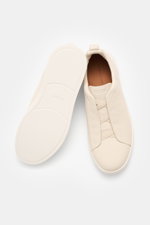 Zegna Slip-on Sneaker 'Triple Stitch' sand shown from above and side, featuring grained leather, crossed elastic bands, and flexible sole.
