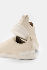 Rear and side view of Zegna Slip-on Sneaker 'Triple Stitch' sand in grained leather with round toe, crossed elastic bands, padded collar, pull tab, ZEGNA embossed tongue, leather lining, and flexible rubber sole.