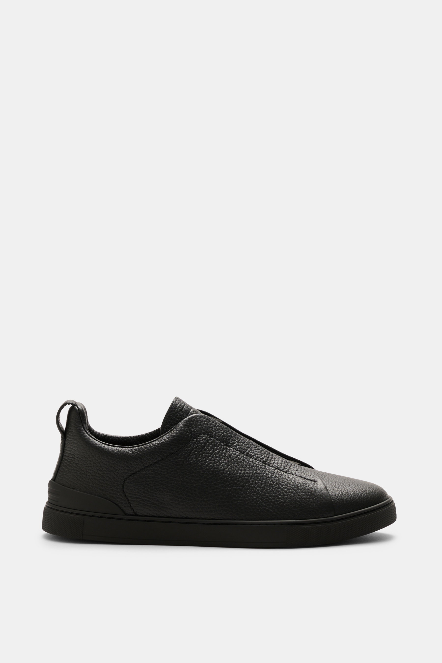 Zegna Slip-on Sneaker 'Triple Stitch' black shown in side profile, made of grained leather with crossed elastic bands, round toe, padded collar, pull tab, ZEGNA embossed tongue, leather lining, and flexible rubber sole. Inspired by ZEGNA's iconic stitchin