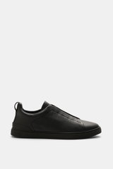 Zegna Slip-on Sneaker 'Triple Stitch' black shown in side profile, made of grained leather with crossed elastic bands, round toe, padded collar, pull tab, ZEGNA embossed tongue, leather lining, and flexible rubber sole. Inspired by ZEGNA's iconic stitchin