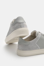 Axel Arigato Sneaker 'Clean 90 Split' grey shown from a rear-side angle, featuring smooth and suede leather, round toe, seven-eyelet lacing, gold label embossing, padded collar, leather lining, and flexible rubber sole.
