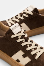 Hogan Sneaker 'Cool Allacciato' dunkelbraun/beige aus Veloursleder mit Memory-Foam-Fußbett, Sieben-Loch-Schnürung, Logo auf Lasche, seitlich H-Initial, flexible Gummisohle, Nahaufnahme von schräg oben.