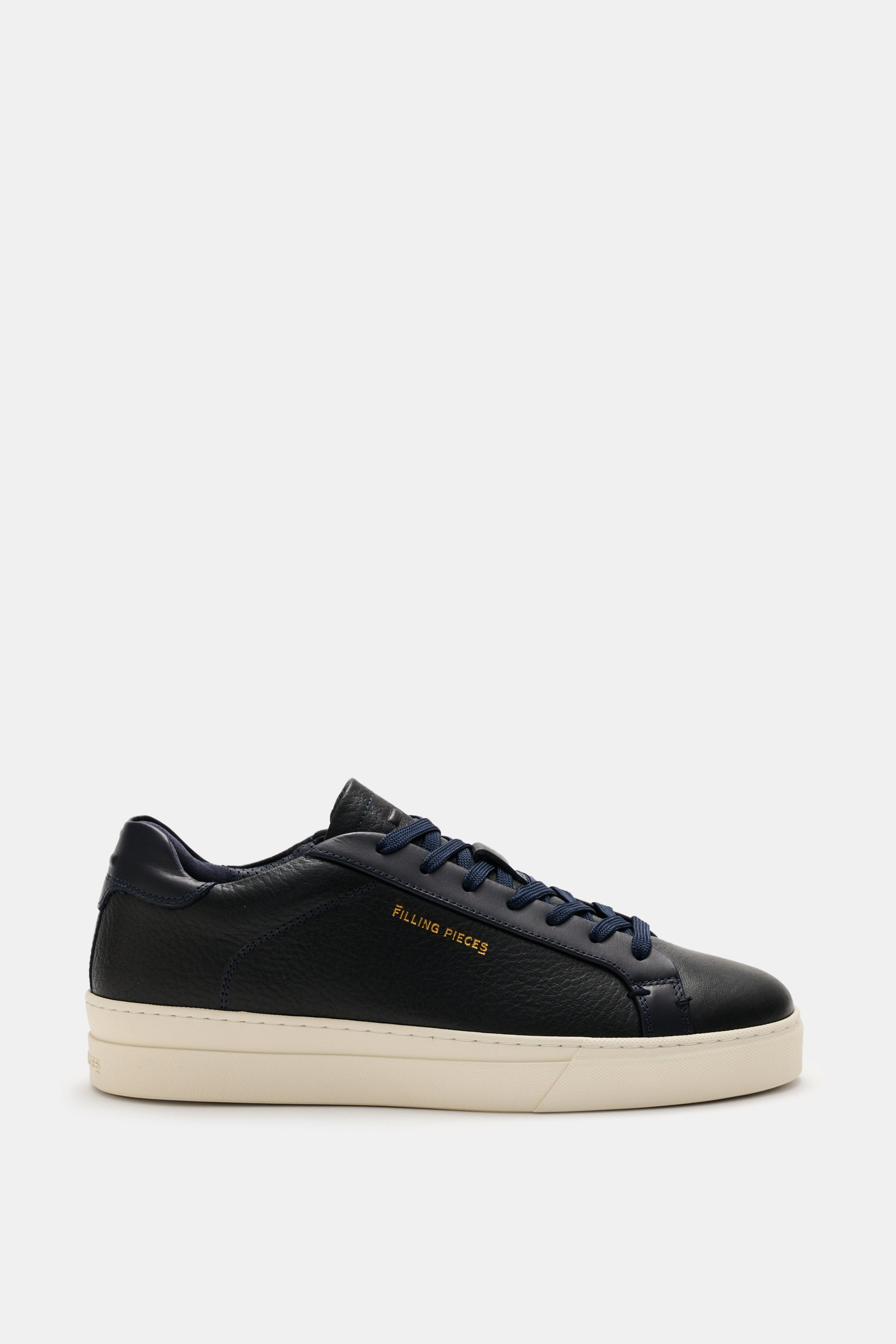 Side view of Filling Pieces Sneaker 'Teabreak Waxed' navy in grained leather with round toe cap, seven-eyelet lacing, padded collar, side logo embossing, perforated leather lining, and rubber sole, showcasing versatility and clean design.