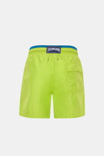 Vilebrequin Swim shorts 'Moka' neon green/teal shown from the back, featuring elastic waistband, side pocket, drainage eyelets, turtle stitching, and VILEBREQUIN label. The high-quality microfibre fabric provides a light touch and regular fit with mesh li