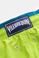 Vilebrequin Swim shorts 'Moka' neon green/teal shown from a close-up rear perspective, highlighting the elastic waistband, VILEBREQUIN woven label, high-quality microfiber, drainage eyelets, and detailed stitching. The swim shorts feature an elasticated w