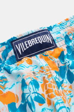Nahaufnahme aus leichter Schräge der Vilebrequin Badeshorts 'Moorea' blau/neonorange gemustert aus hochwertiger Microfaser mit VILEBREQUIN-Weblabel.