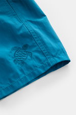 Nahaufnahme der Vilebrequin Badeshorts 'Moorea Magic' petrol, wasserreaktiv aus hochwertiger Microfaser mit gestickter Schildkröte, tonalem Stitching, Regular Fit und elastischem Bund.